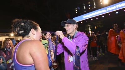 A female final finisher receives her medal at the finish line