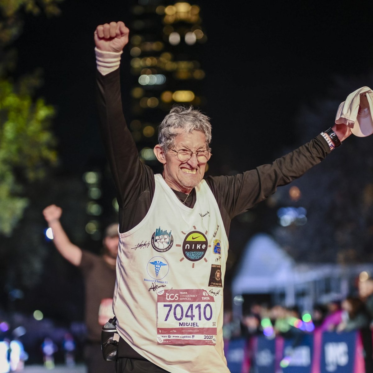A final finisher crosses the finish line with his arms outstretched overhead