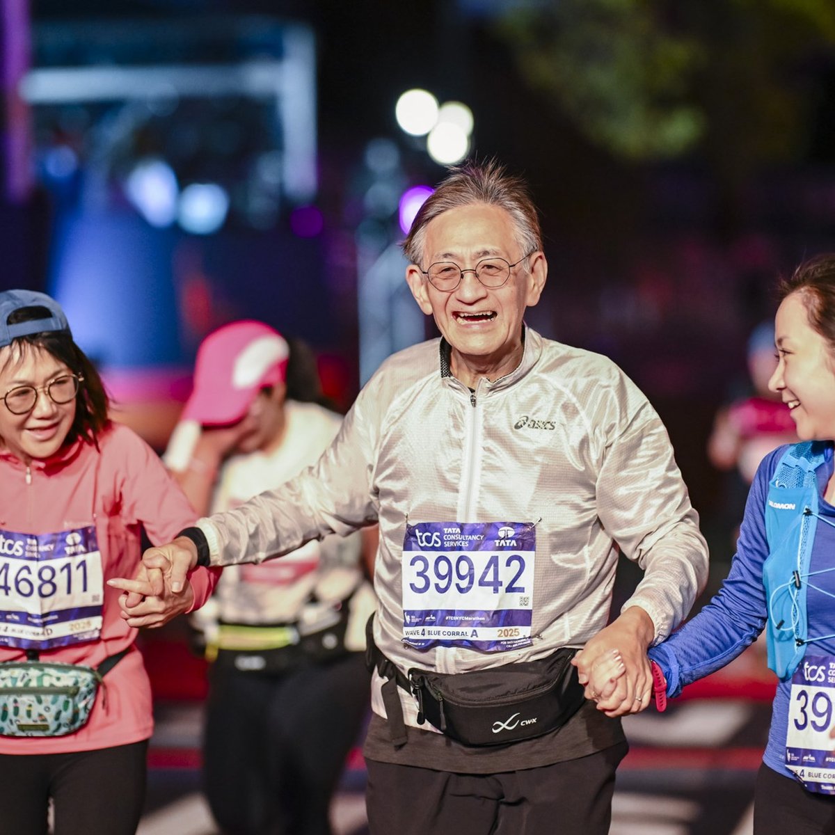 Three final finishers cross the finish line holding hands