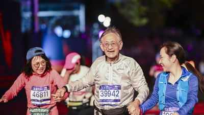 Three final finishers cross the finish line holding hands