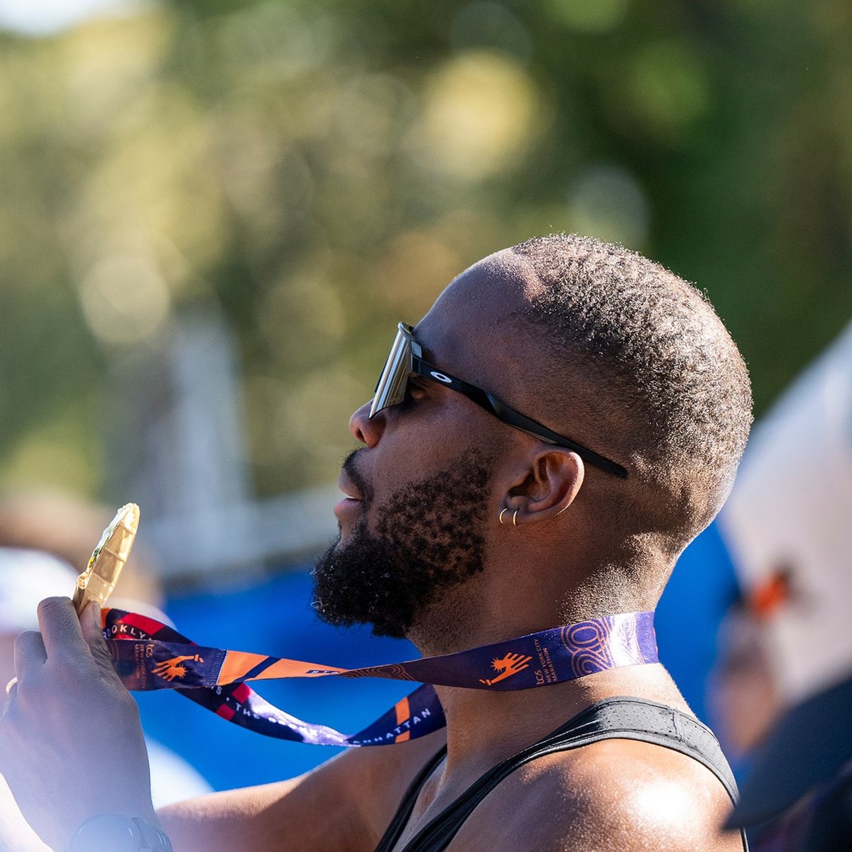 A male runner takes a selfie with his TCS New York City Marathon medal