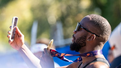 A male runner takes a selfie with his TCS New York City Marathon medal