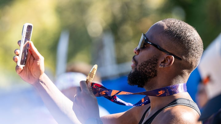 A male runner takes a selfie with his TCS New York City Marathon medal