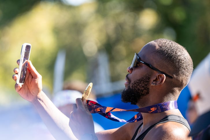 A male runner takes a selfie with his TCS New York City Marathon medal