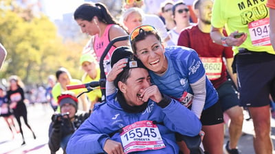 A female AWD athlete in a wheelchair cries and is elated at the finish line of the TCS New York City Marathon