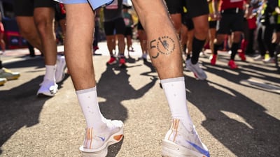 A man's legs with a 50th TCS New York City Marathon on his right calf