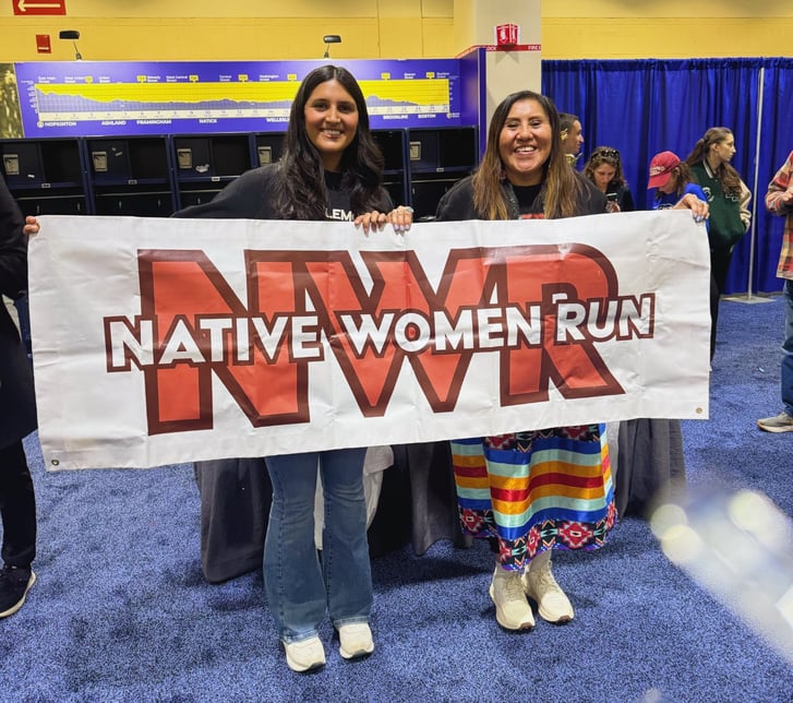 Hope and Verna holding up a Native Women Run banner.