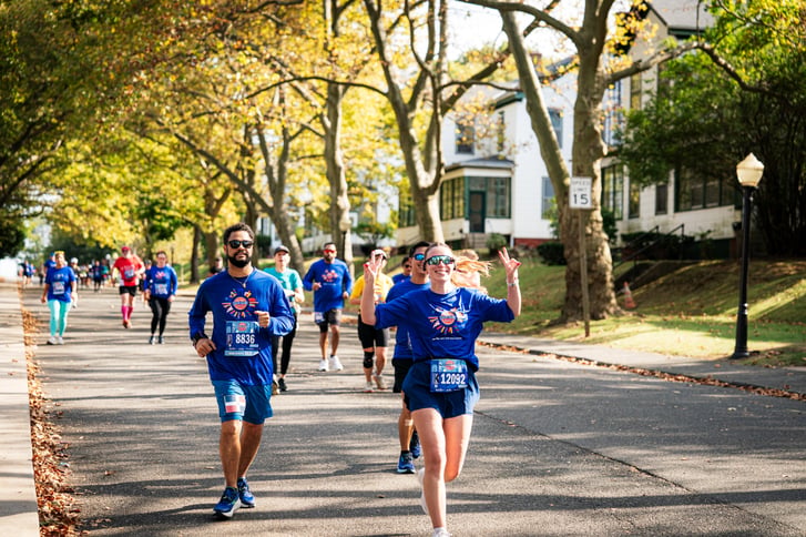 Runners on treelined street in 2024 NYRR Staten Island Half