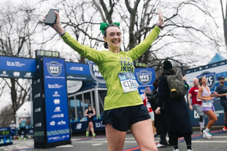 Team for Kids woman runner finishing 2025 UA NYC Half