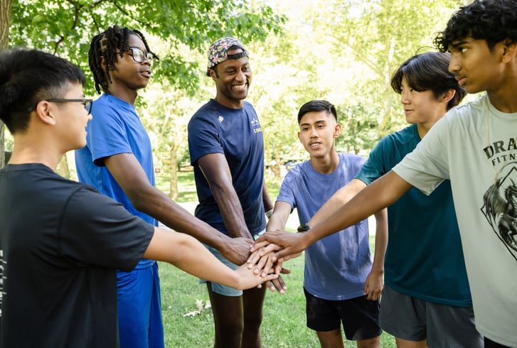 Young men group high five at Summer Practice 2026