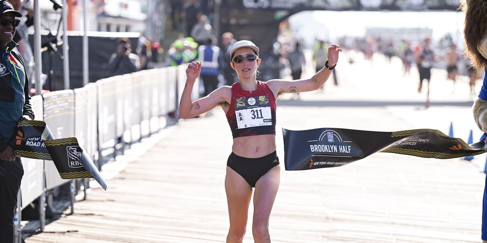 Danica Reinicke breaking the tape to win the nonbinary division of the 2026 RBC Brooklyn Half on the Coney Island boardwalk.