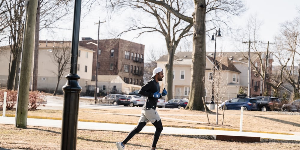 Man running at NYRR Open Run next to a pond in Lincoln Park, Jersey City, winter 2025.