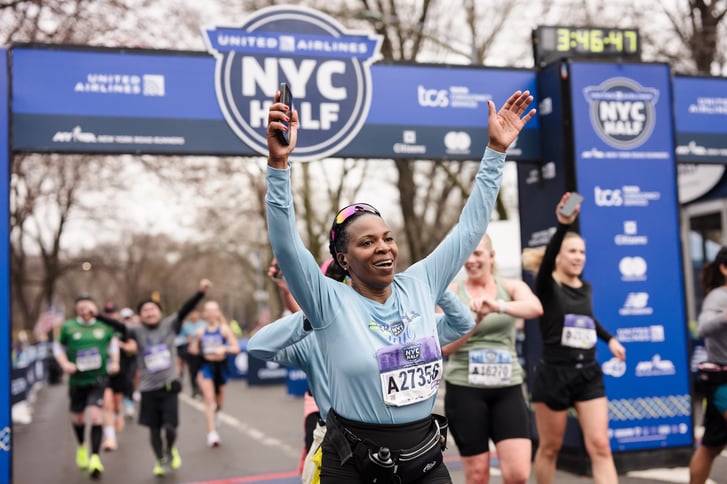 Runner with hands up at the finish line of the 2025 United Airlines NYC Half