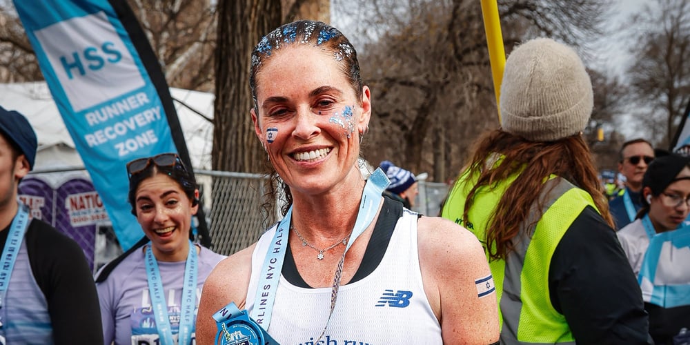 Tehila Novak with Nice Jewish Runners singlet holding medal after 2026 UA NYC Half in Central Park NYC
