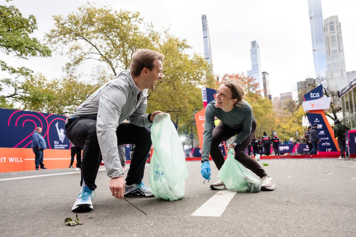 two people picking up litter and smiling at each other