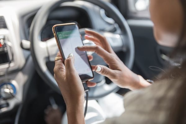 Close-up of hands holding a phone and tapping a maps app