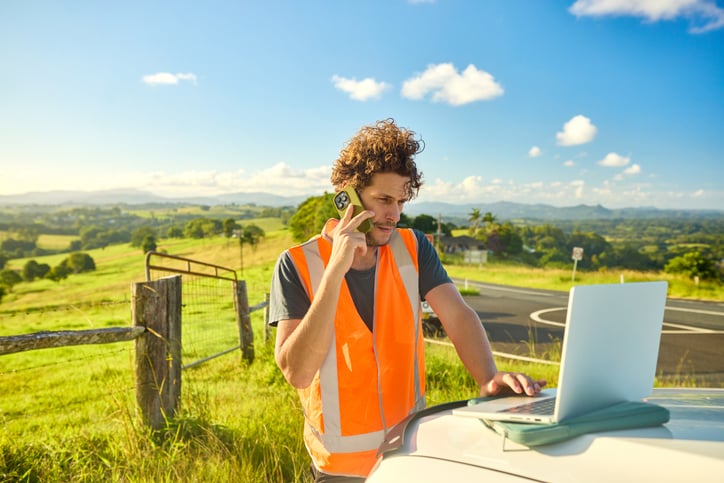 A tradesperson on a job while an AI system answers an incoming call