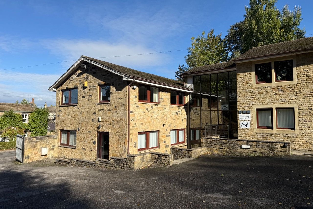 The two stone office buildings at West Chevin Business Centre, joined by a glazed entrance, with the car park in front