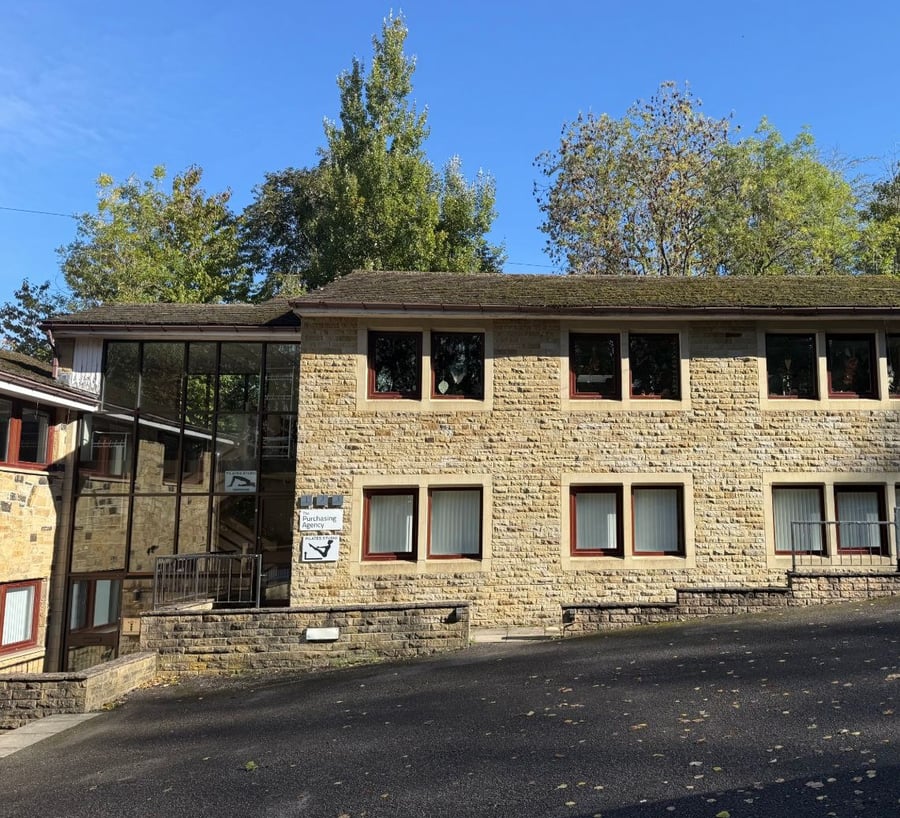 Front of the two-storey stone office building at West Chevin Business Centre, with tall trees behind