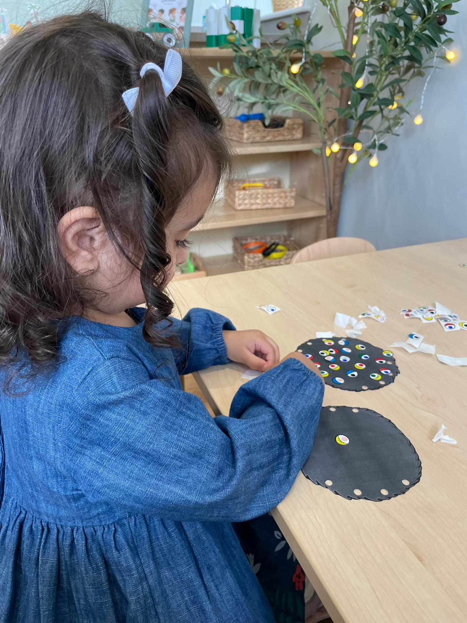 A child concentrating on a craft activity at the table