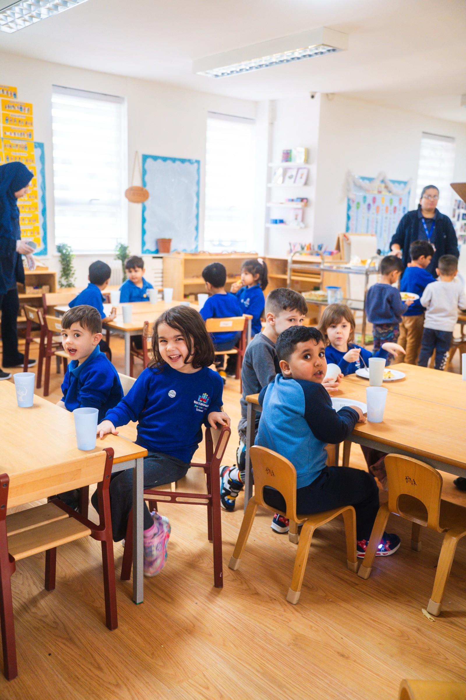 A bright, busy nursery classroom full of happy children at their tables