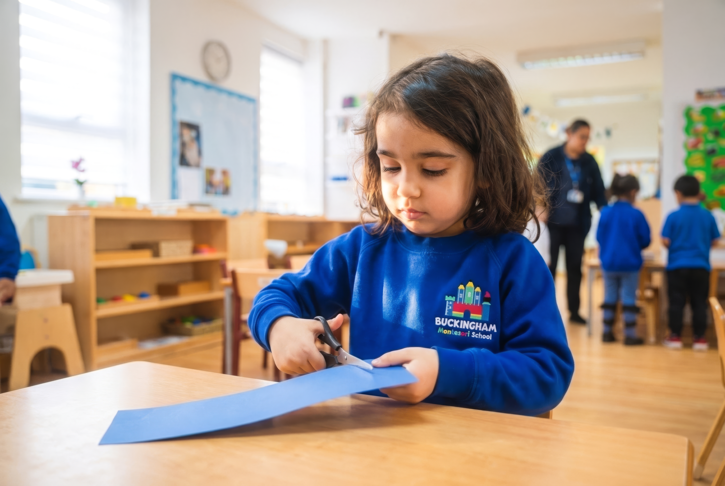 Girl practising cutting with scissors — Montessori practical life