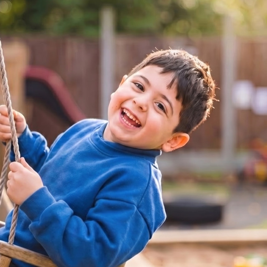 Boy laughing on the garden swing