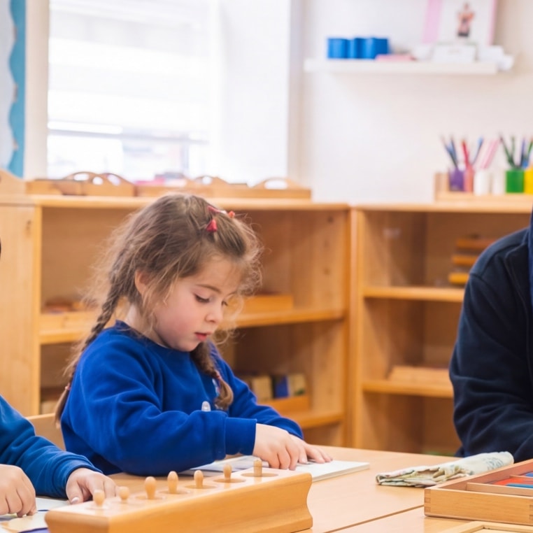Hijabi teacher working with group of children at table