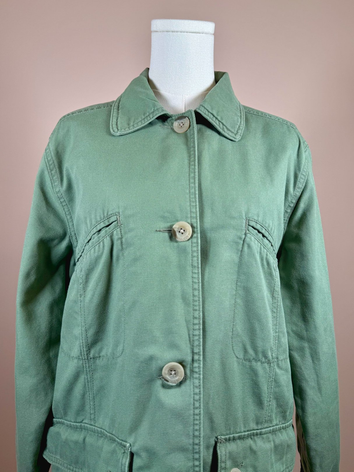 Sage green quilted jacket for women from the 1970s featuring a collar and button closure.