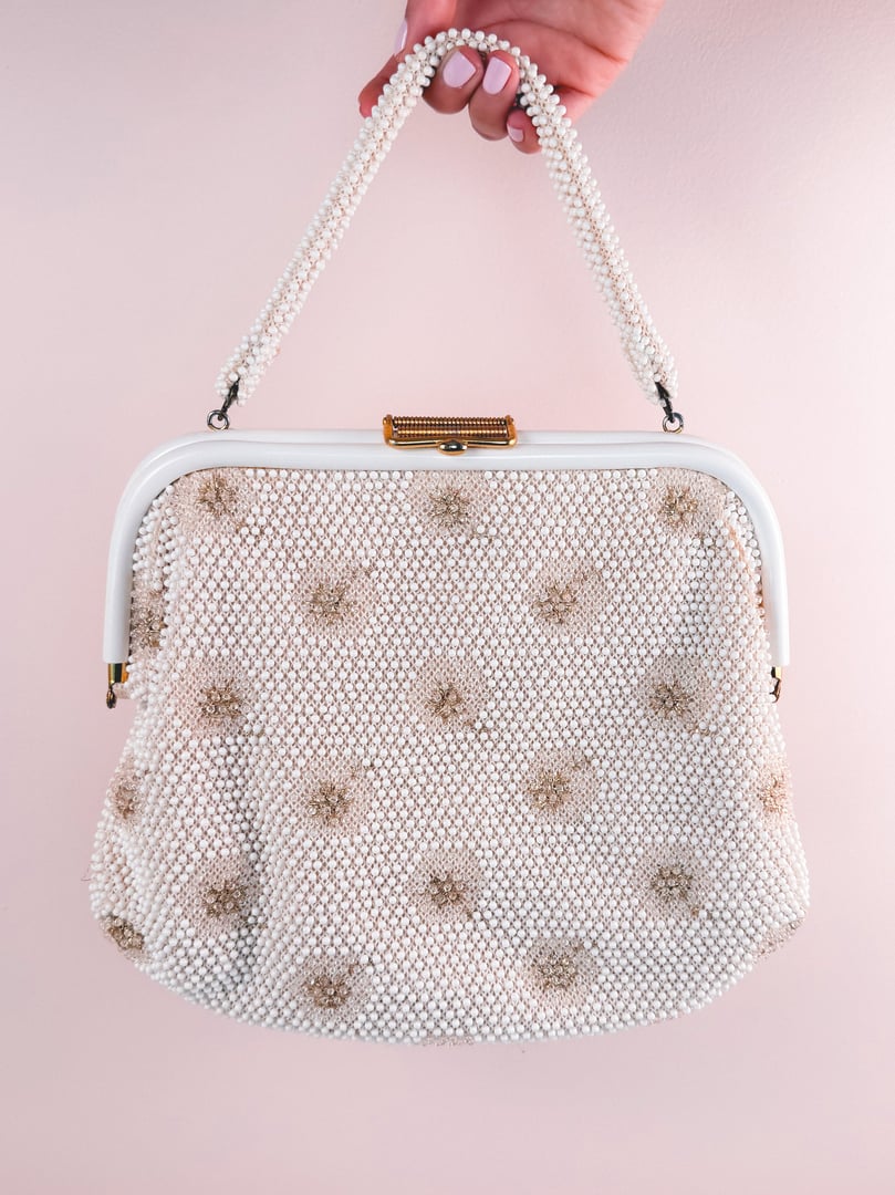 Cream white 1950s handbag with a beaded sparkle design and a structured handle.