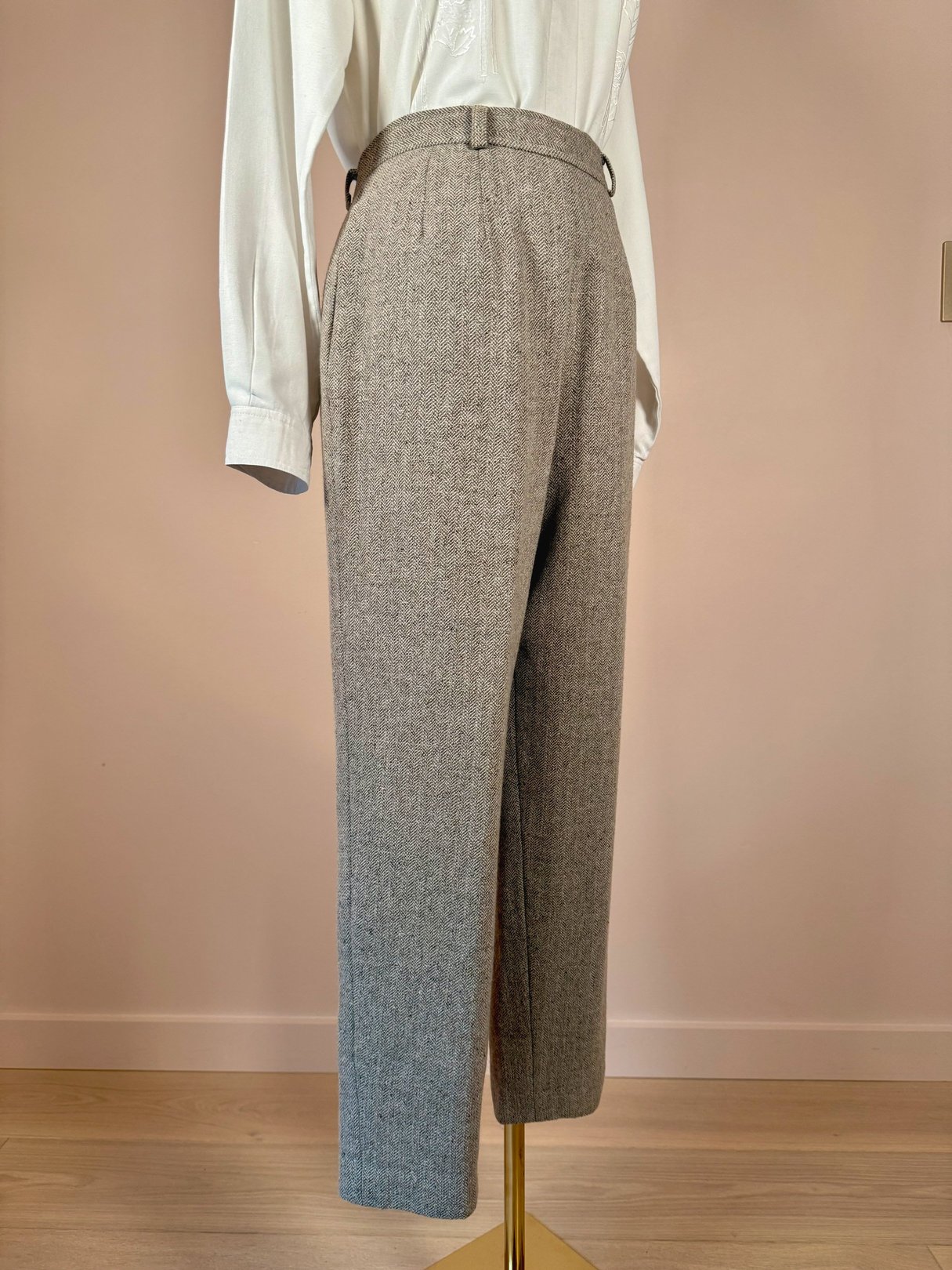 Tan birch tweed pants with a high waist and side pockets, styled with a loose white blouse, showcased on a mannequin against a neutral background.