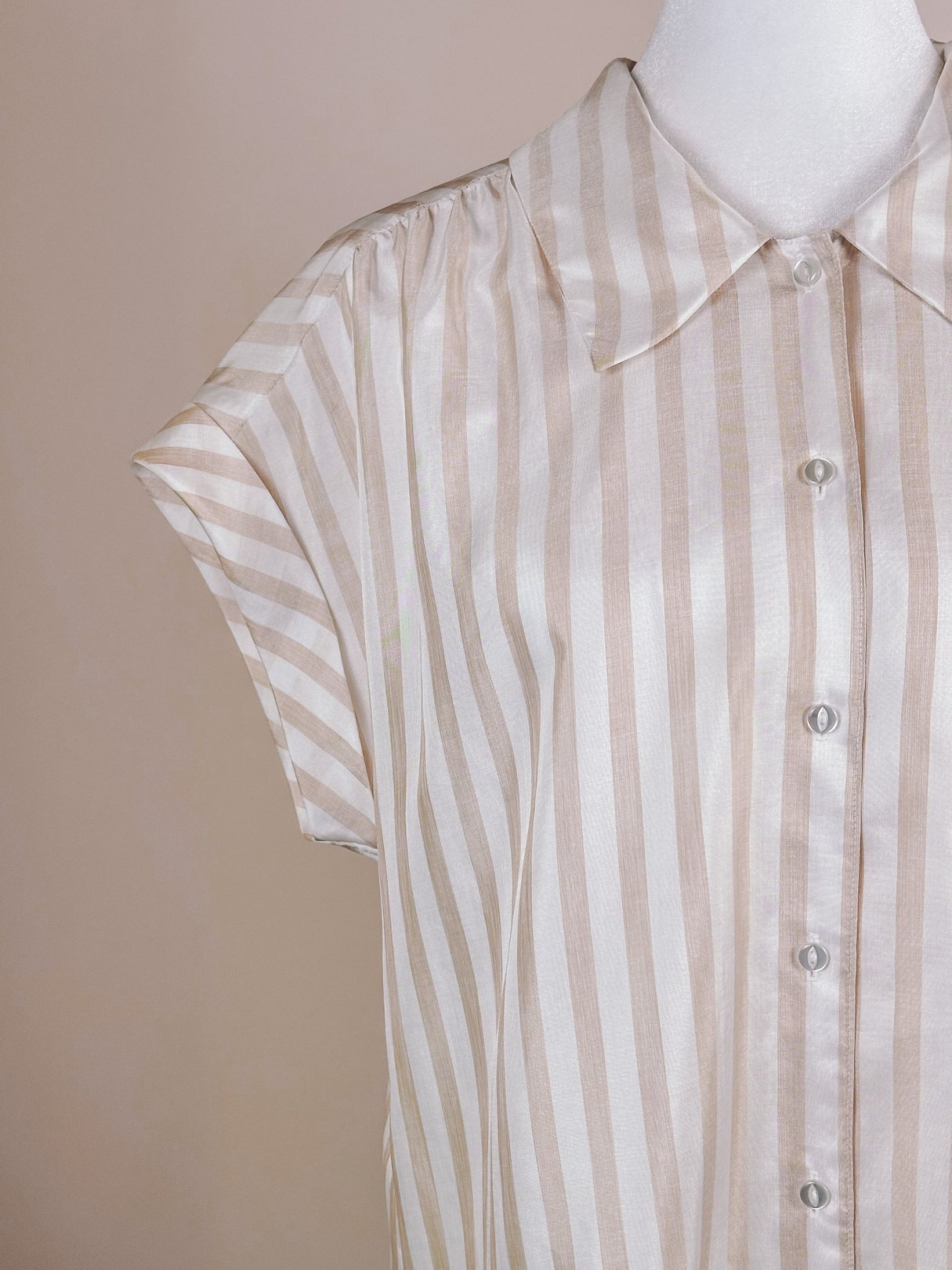 Chic 1970s striped blouse featuring a classic retro design in white with tan and blush stripes, designed for women.