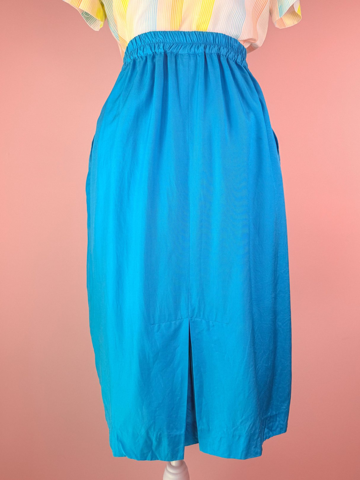 Turquoise blue women’s skirt from the 1980s featuring an elastic waistband and a front split.