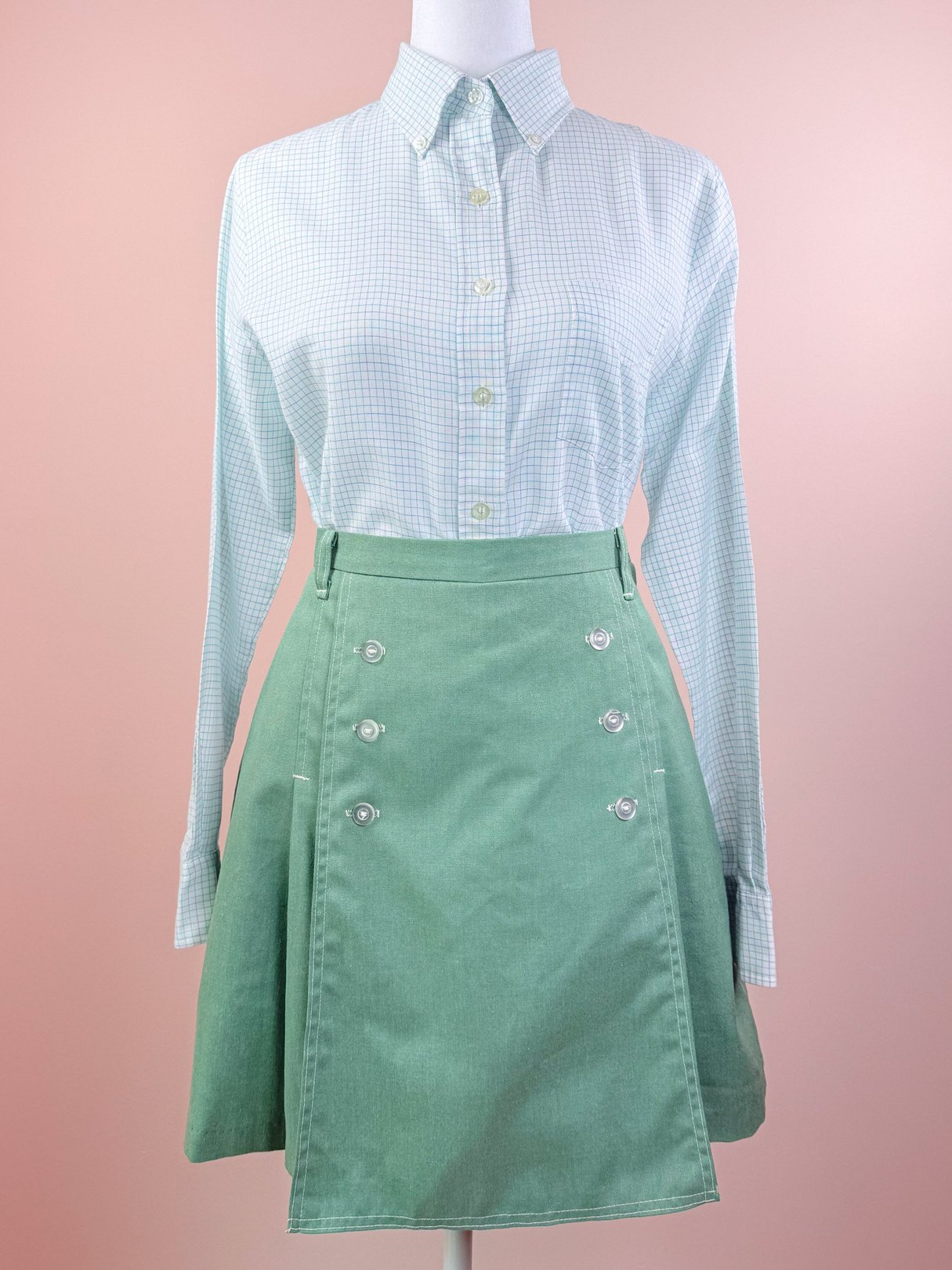 Vintage 1970s green Gator Sailor Skort featuring a buttoned front and paired with a light blue checkered long-sleeve shirt.