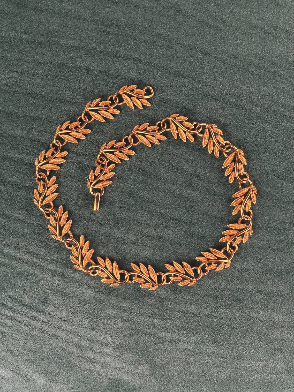 Gold-tone collar necklace featuring a swirled vine design, typical of 1970s women's jewelry.