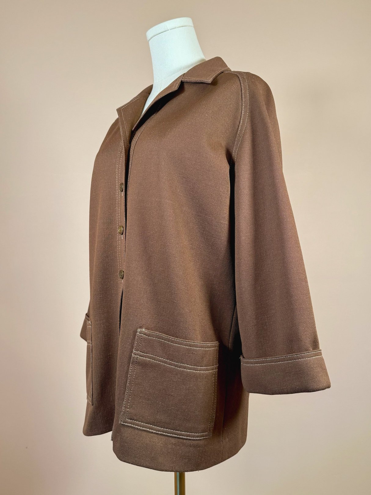 1960s women's brown chestnut jacket with a collared neckline, front buttons, and large patch pockets.