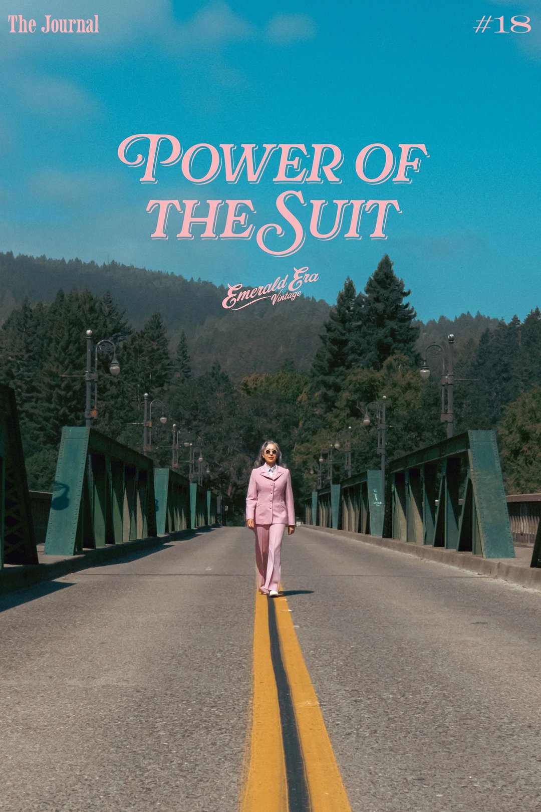 A person in a pink suit stands confidently on a bridge with a blue sky and trees in the background, featuring the text "Power of the Suit" and "The Journal #18" at the top.