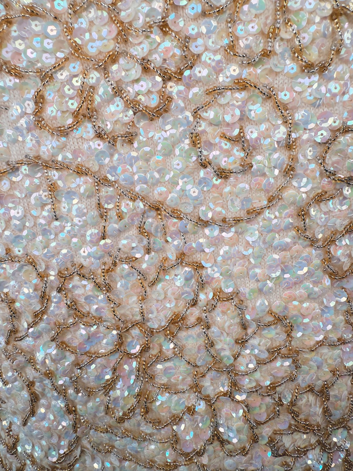 The Champagne Blossom Top features a 1960s design with intricate white sequin embellishments and gold thread detailing.