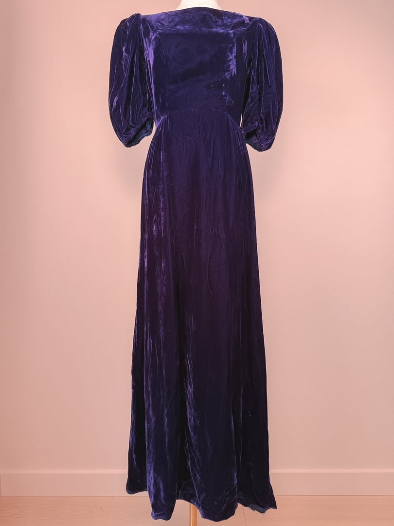 Long purple velvet dress with puff sleeves and a flowing silhouette from the 1960s.