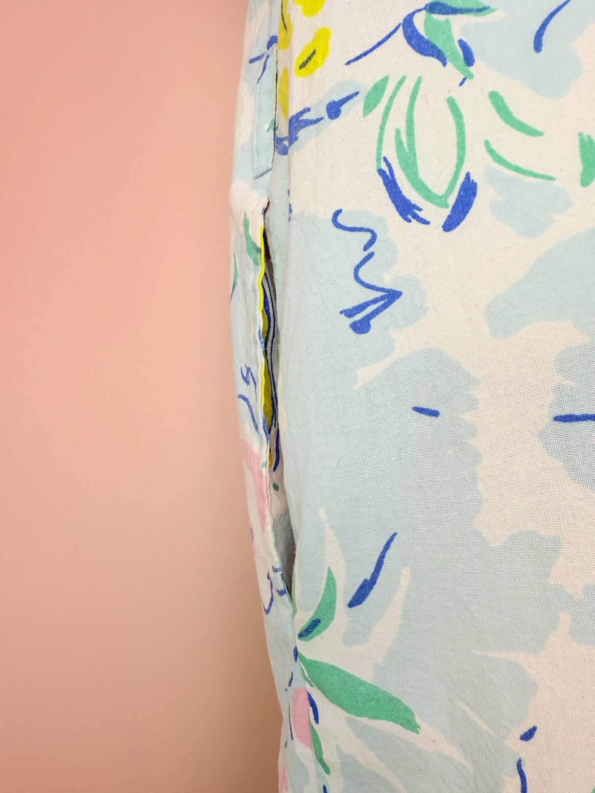 A blue 1980s women's romper featuring a colorful tropical floral print.