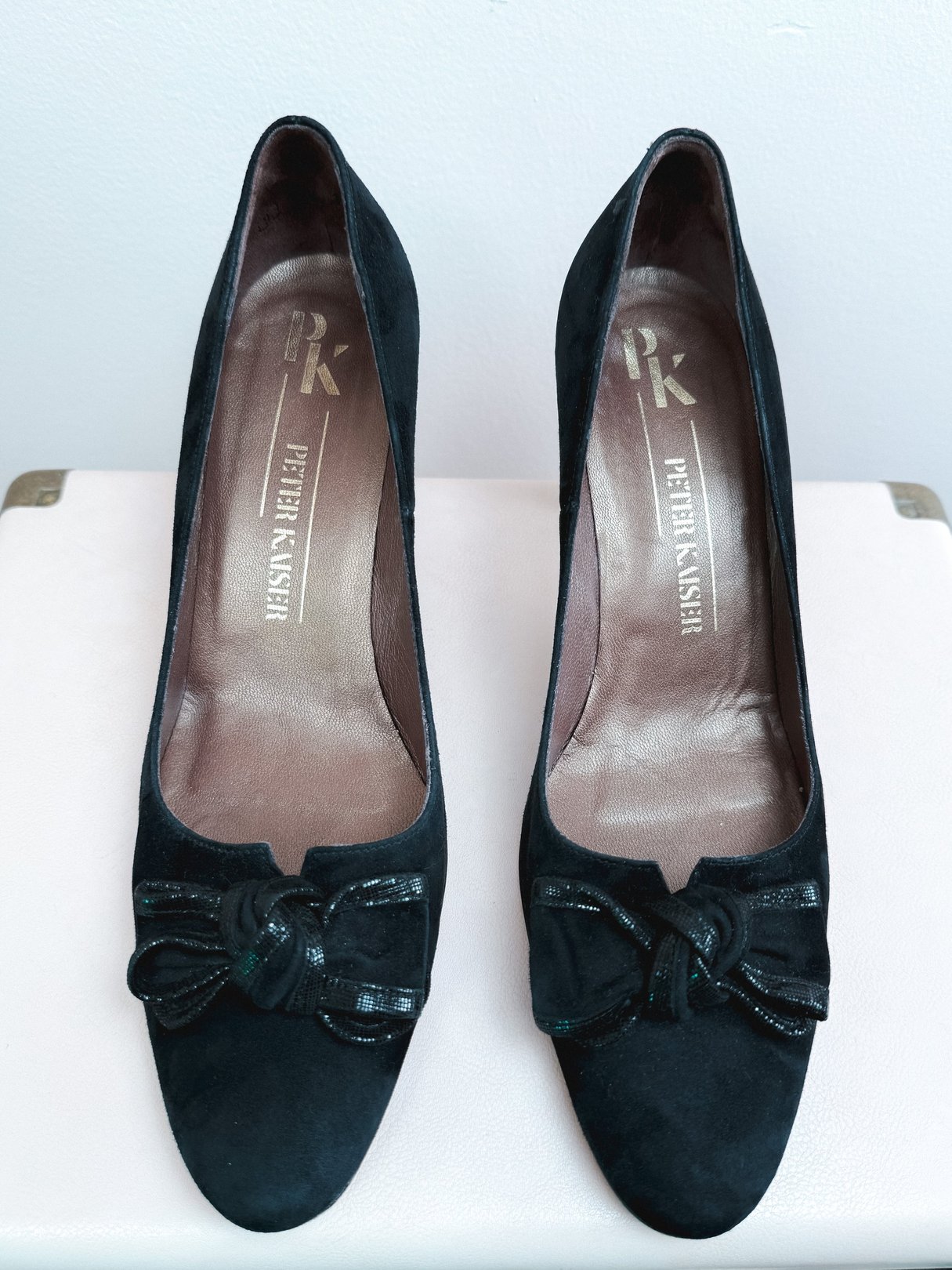Black suede pumps for women from the 1970s with a bow detail on the toe and a high heel.