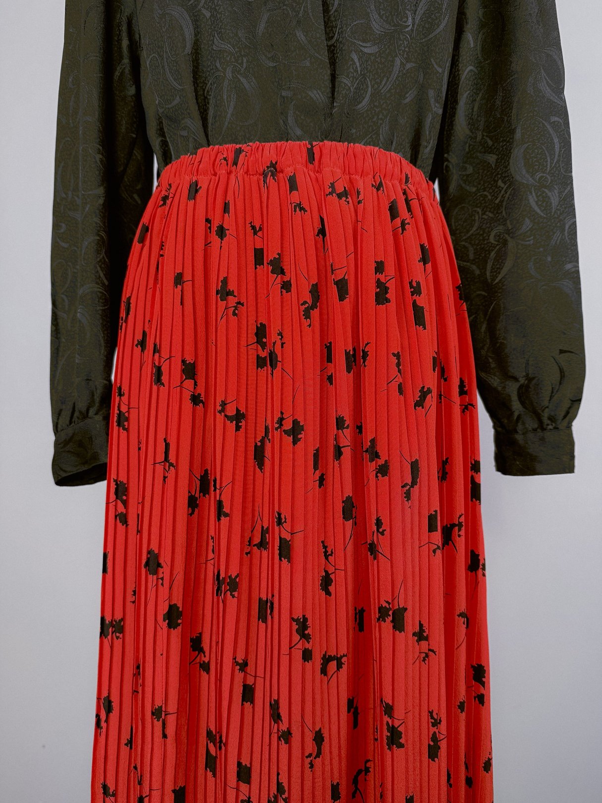 Midnight Waltz Pleated Skirt featuring a red pleated design adorned with black floral patterns, suitable for women and inspired by 1970s fashion.