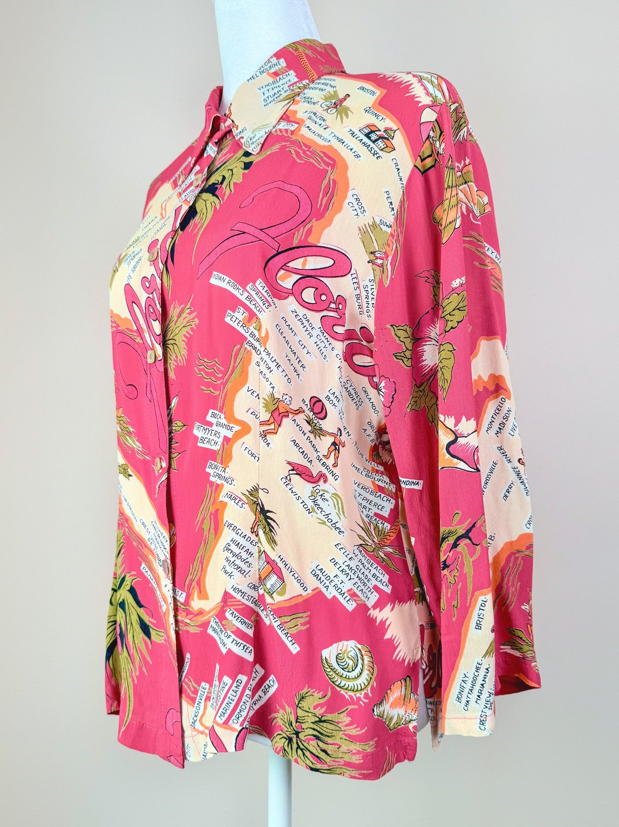 1970s women's white top featuring a colorful Florida-themed graphic and button-up front.