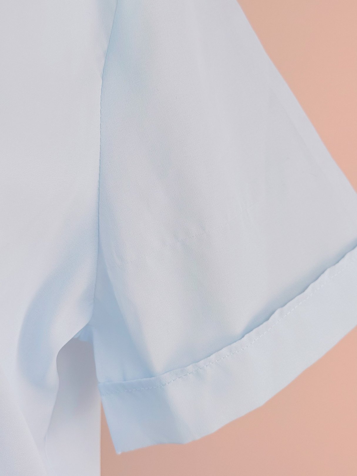 Powder blue blouse with short sleeves, made of lightweight fabric, featuring a clean hem.