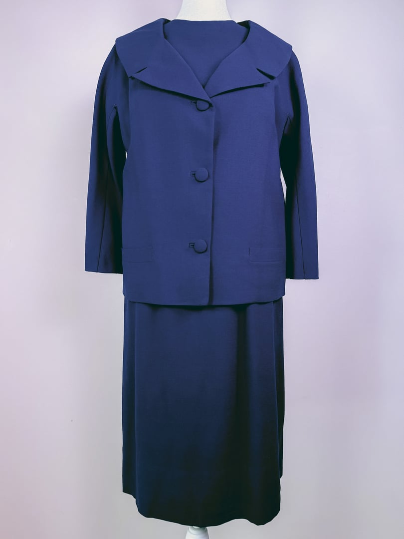 Navy blue 1960s women's dress set featuring a knee-length dress with a matching jacket and large collar.