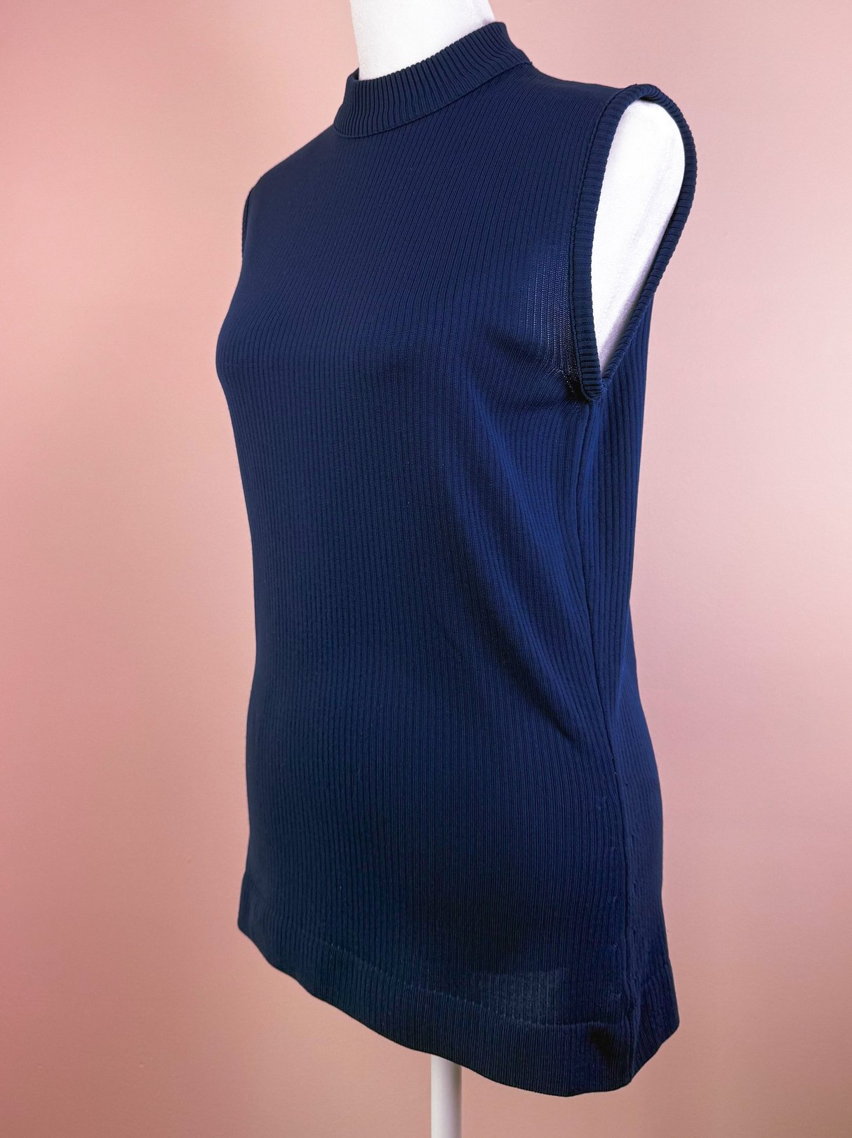 Navy blue ribbed mock neck top for women, featuring a sleeveless design and a fitted silhouette, inspired by 1970s fashion.