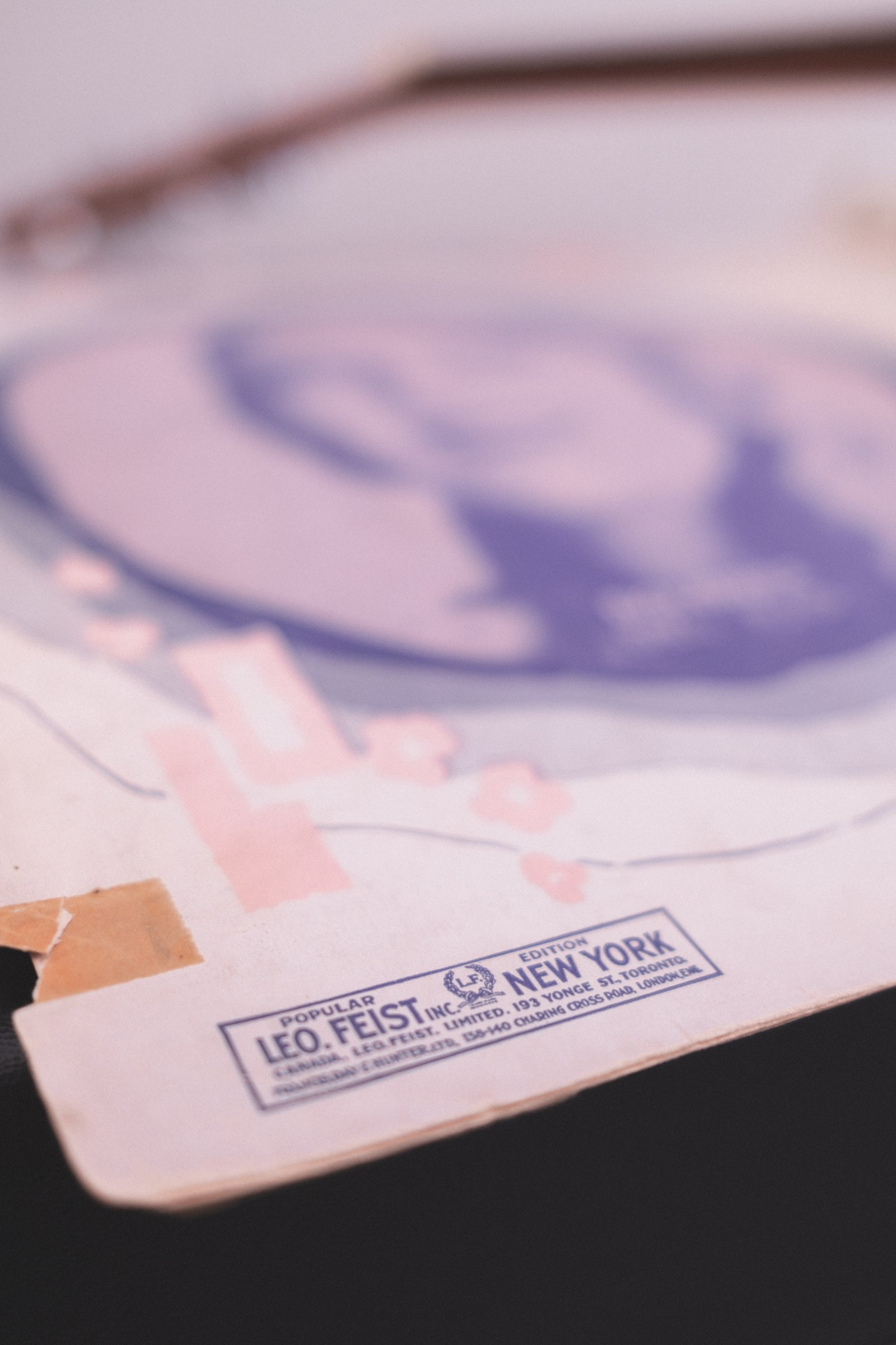 Sheet Music Stories gallery image: Sheet music featuring a cover design with a prominent pink and purple illustration, labeled with the publisher Leo Feist, Inc., New York.