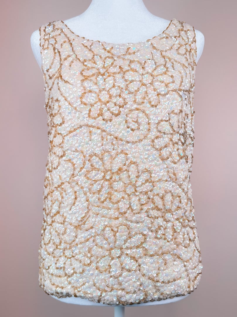 White floral beaded top with a sleeveless design, reflecting 1960s fashion and categorized under Sparkle and Tops.