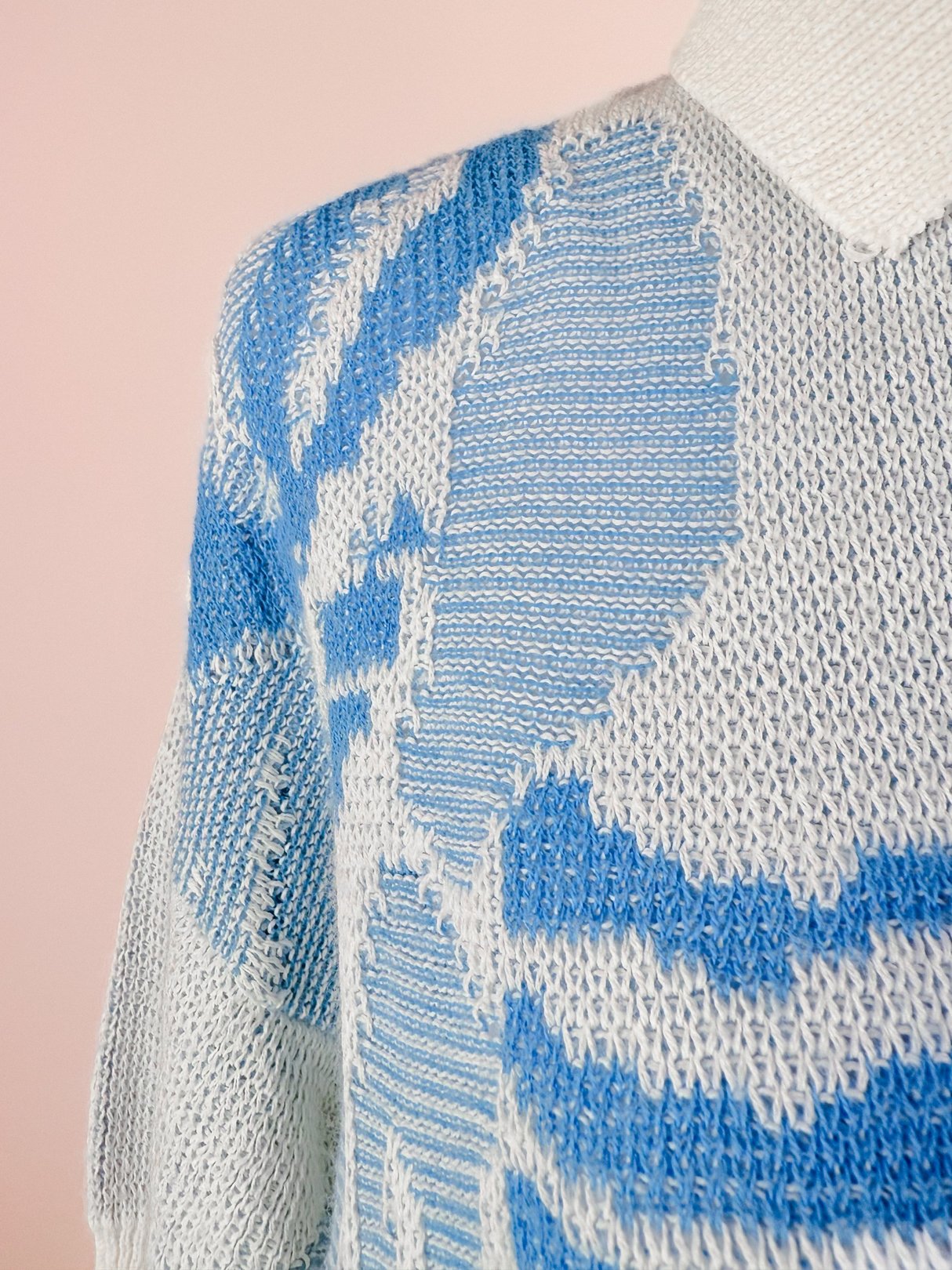 White 1980s women's Yasaki knit polo sweater featuring a blue abstract design and a collared neckline.