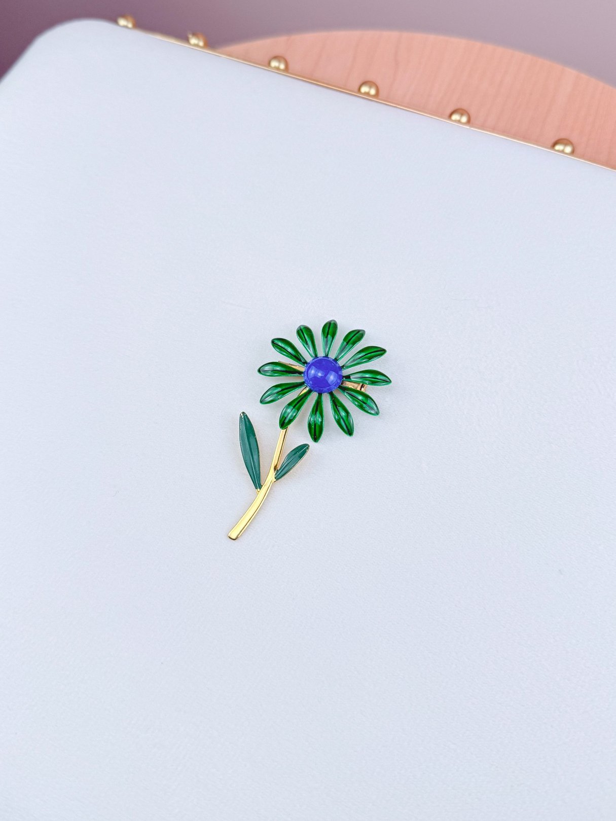Blue and green floral brooch with a gold-tone stem designed for women, inspired by 1960s style.
